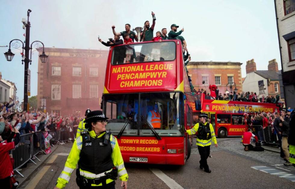 Members of the Wrexham FC soccer team ride on an open top bus as they celebrate promotion to th ...