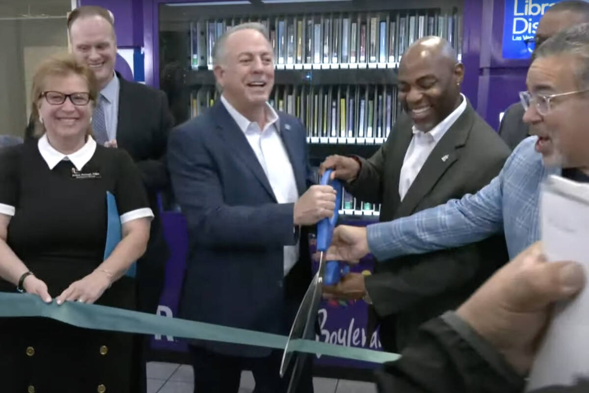 Gov. Joe Lombardo, center, helps cut the ribbon for a new Las Vegas-Clark County Library Distri ...