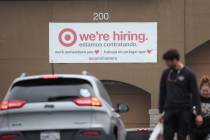 People walk by a hiring sign posted on the exterior of a Target store on April 7, 2023, in Nova ...