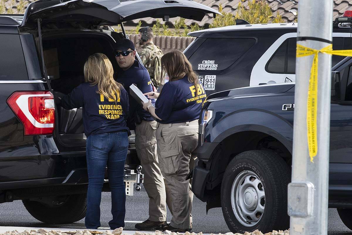 Members of the FBI's Evidence Support Team converse outside of Matthew Beasley's home while neg ...