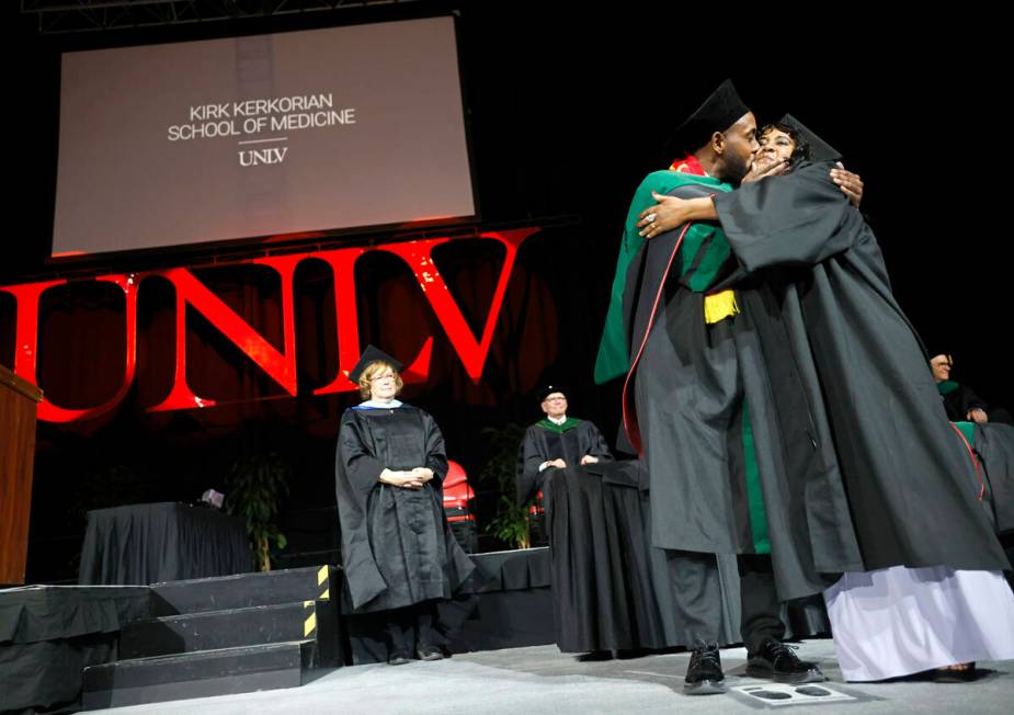 Sami Mesgun kisses his mother Azmara Zeratsion after he was hooded by Zeratsion during the comm ...