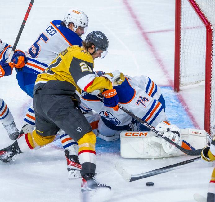 Golden Knights center Brett Howden (21) has a shot attempt rejected by Edmonton Oilers goaltend ...