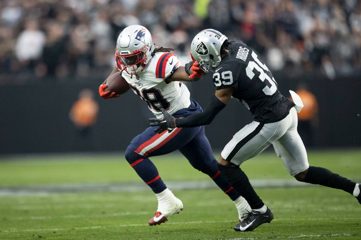 New England Patriots running back Rhamondre Stevenson (38) stiff arms Raiders cornerback Nate H ...