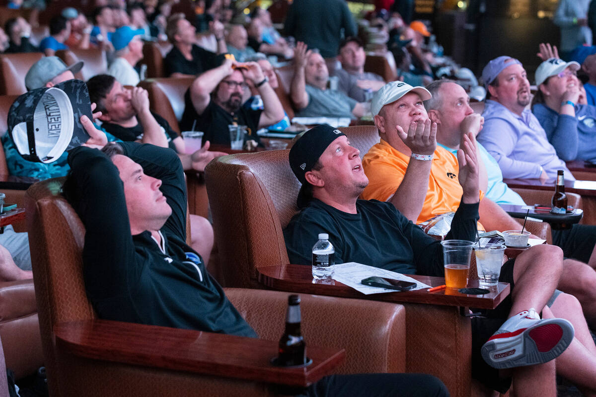 Guests watch on the big screens during the first day of the NCAA basketball tournament at the S ...