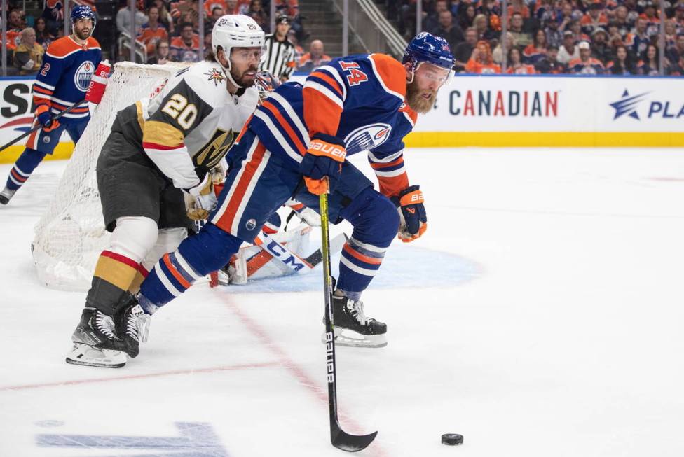 Vegas Golden Knights' Chandler Stephenson (20) and Edmonton Oilers' Mattias Ekholm (14) battle ...