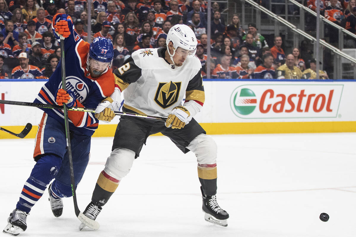 Vegas Golden Knights' Zach Whitecloud (2) and Edmonton Oilers' Warren Foegele (37) battle for t ...