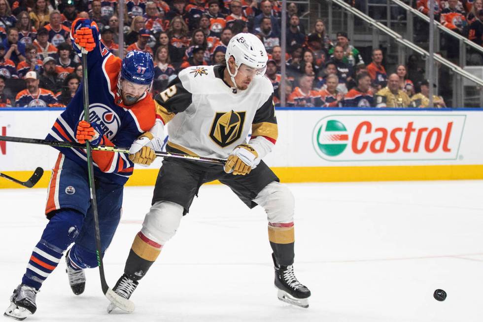 Vegas Golden Knights' Zach Whitecloud (2) and Edmonton Oilers' Warren Foegele (37) battle for t ...