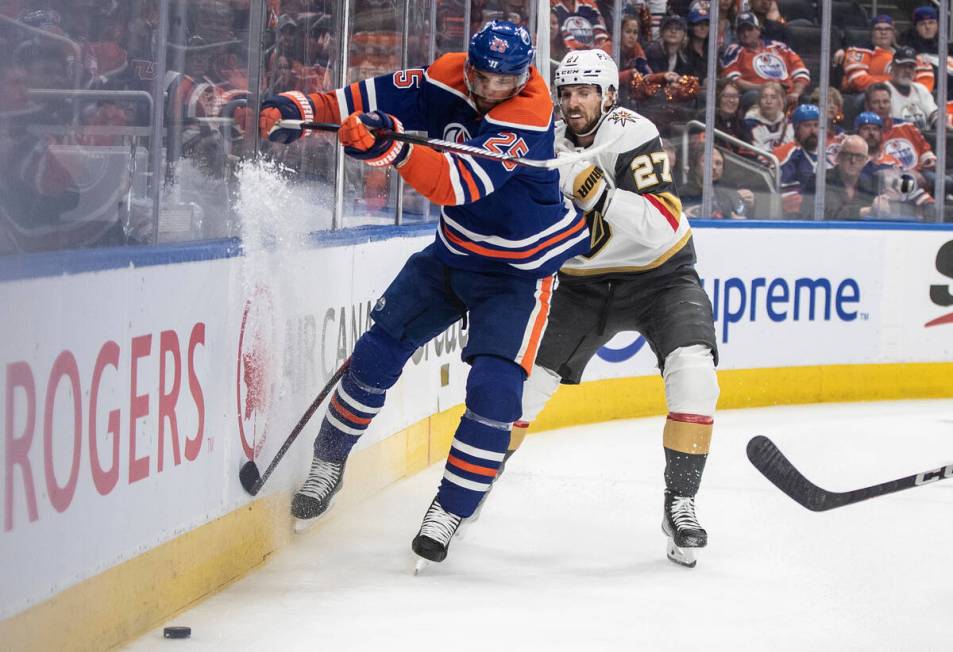 Vegas Golden Knights' Shea Theodore (27) checks Edmonton Oilers' Darnell Nurse (25) during the ...