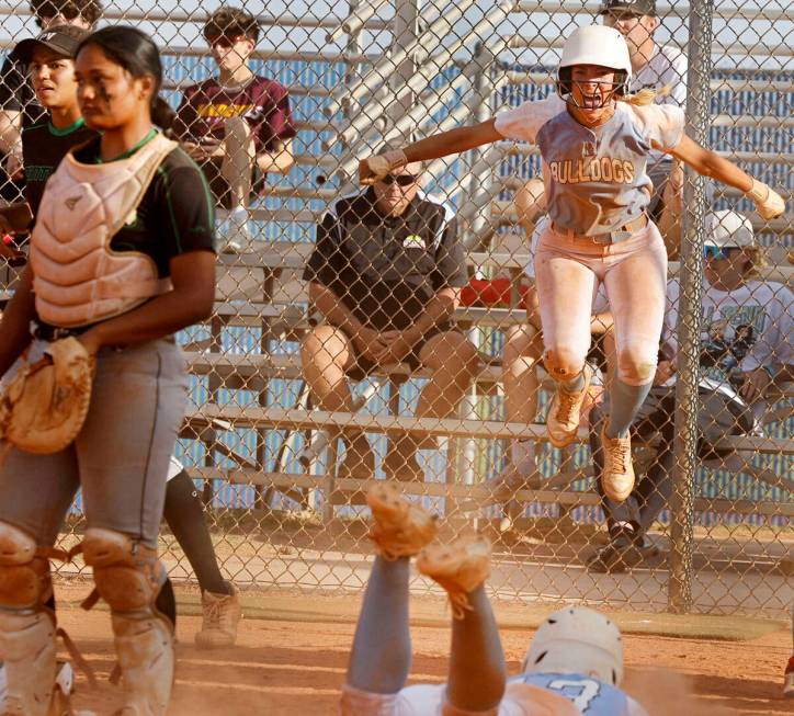 Centennial's Jill Halas (11), right, jumps as Centennial's Keana Bell (13), bottom, slides safe ...