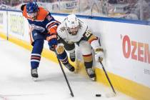 Vegas Golden Knights' Chandler Stephenson (20) and Edmonton Oilers' Evan Bouchard (2) reach for ...