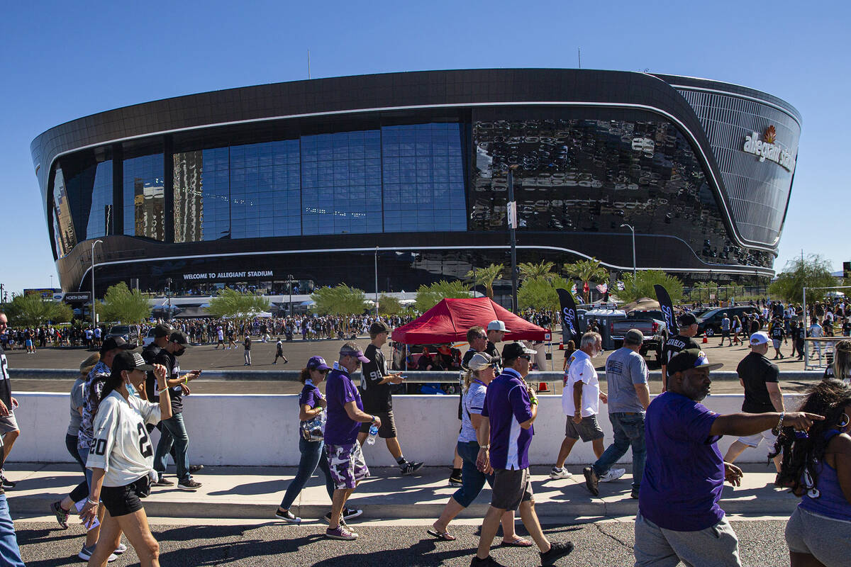 Football fans walk along the Hacienda Bridge before an NFL game between the Raiders and the Bal ...