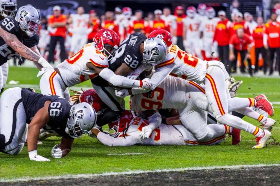 Raiders running back Josh Jacobs (28) battles to get to the end zone versus Kansas City Chiefs ...