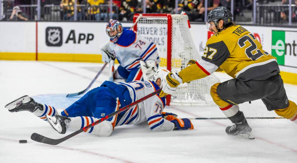 Golden Knights defenseman Shea Theodore (27) battles for control of the puck over Edmonton Oile ...