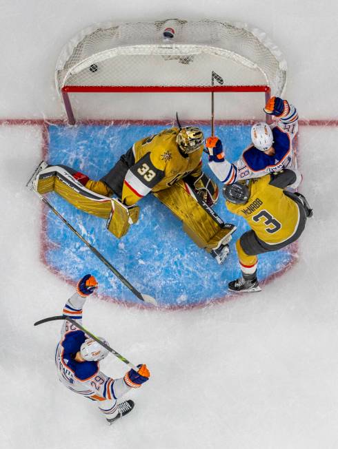 Golden Knights goaltender Adin Hill (33) misses a diving block as Edmonton Oilers left wing Zac ...