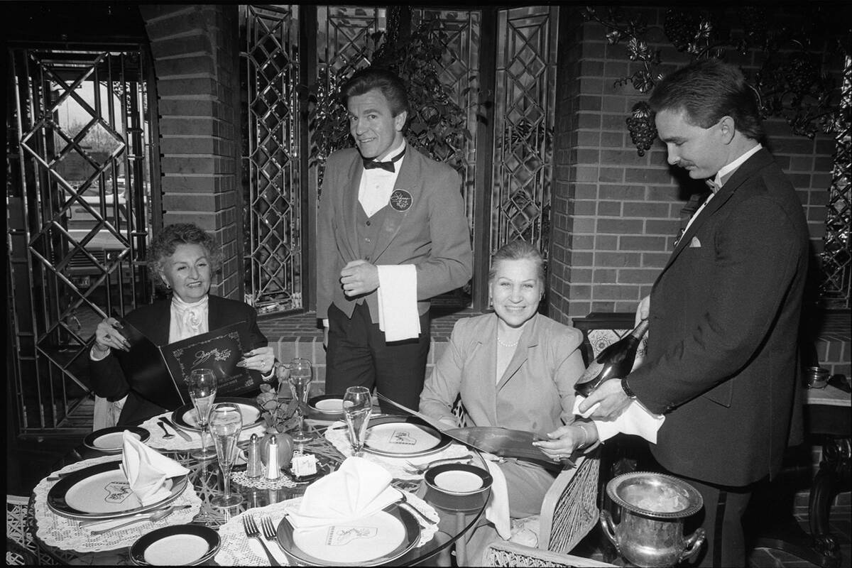 Angie Liberace (left) and Olga Perez are served by waiter Peter Petteson (left) and maitre d' B ...