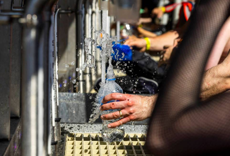 Attendees refill water bottles due to the heat during the Sick New World festival at the Las Ve ...