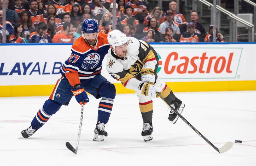 Vegas Golden Knights' Jack Eichel (9) and Edmonton Oilers' Brett Kulak (27) battle for the puck ...