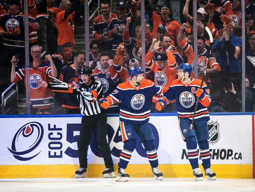 Edmonton Oilers' Brett Kulak (27) and Connor McDavid (97) celebrate a goal against the Vegas Go ...