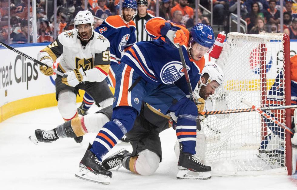 Vegas Golden Knights' William Carrier (28) is checked by Edmonton Oilers' Mattias Janmark (26) ...