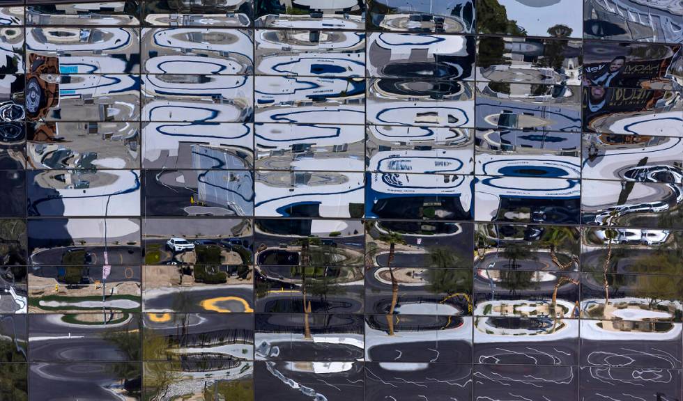 The parking lot and beyond reflected in the glass on Allegiant Stadium on Thursday, March 16, 2 ...