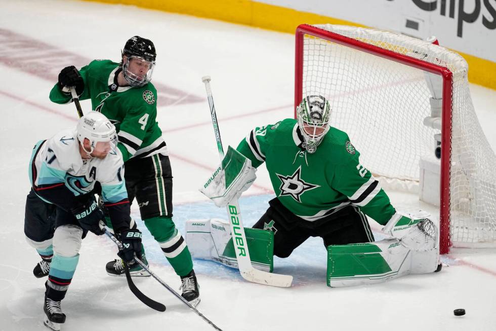 Dallas Stars goaltender Jake Oettinger defends against a shot as defenseman Miro Heiskanen (4) ...