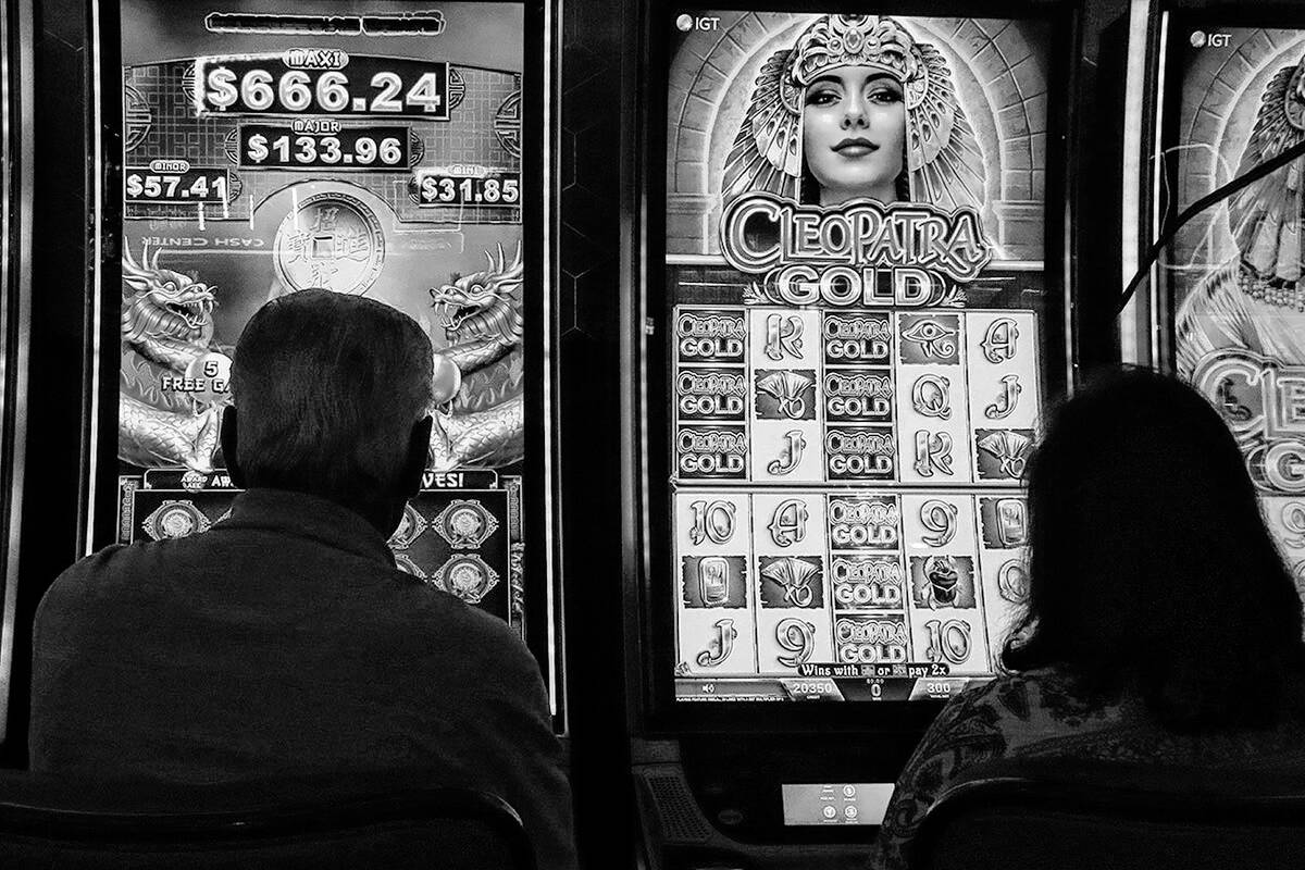 Gamblers are silhouetted against the light from slot machines on Aug. 8,2022 at the Hard Rock c ...