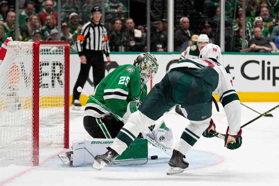 Dallas Stars goaltender Jake Oettinger (29) blocks a shot under pressure from Minnesota Wild le ...