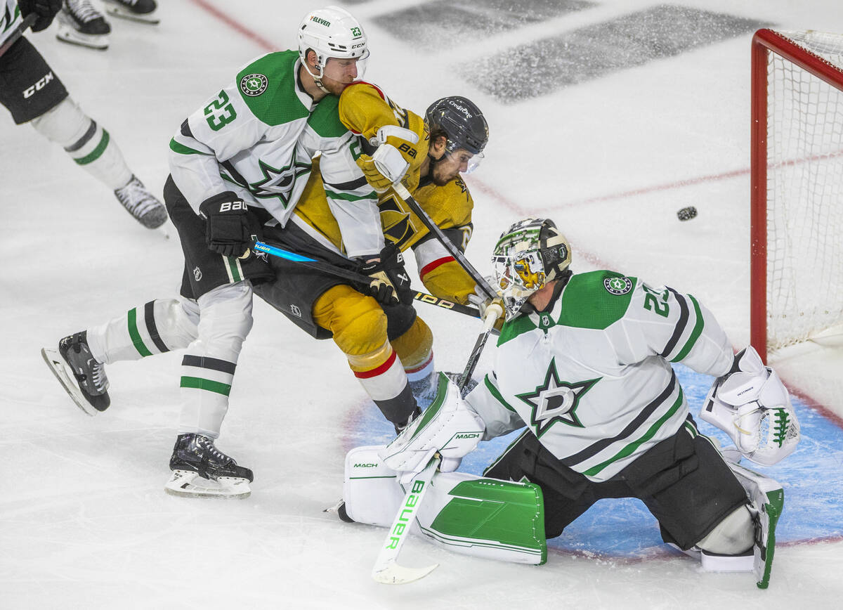 Golden Knights center Brett Howden (21) battles to score with Dallas Stars defenseman Esa Linde ...