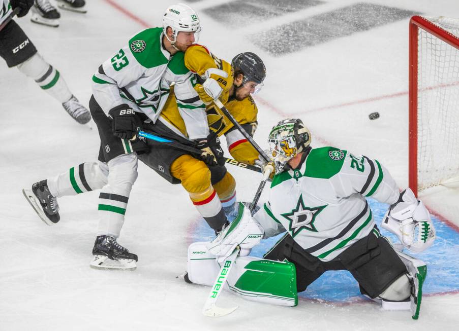 Golden Knights center Brett Howden (21) battles to score with Dallas Stars defenseman Esa Linde ...