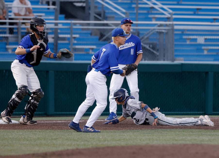 Damonte Ranch High's Ayden Grace (2) slides safe at third as Bishop Gorman High's catcher Burke ...