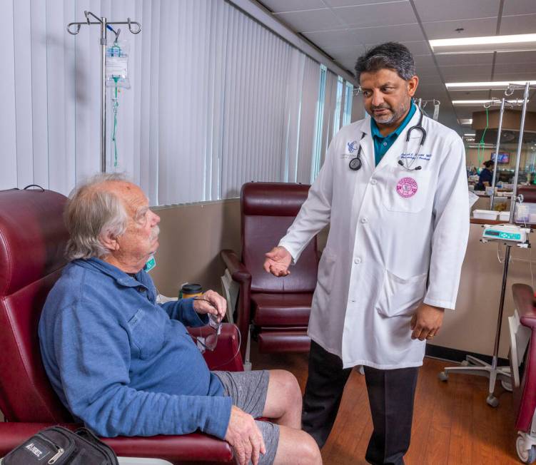 Dr. Rupesh Parikh, right, chats with patient Scott Long of Las Vegas in the chemo treatment roo ...