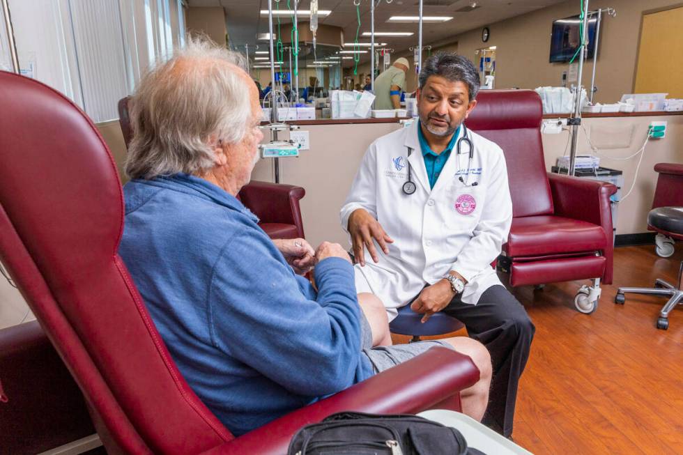 Dr. Rupesh Parikh, right, chats with patient Scott Long of Las Vegas in the chemo treatment roo ...