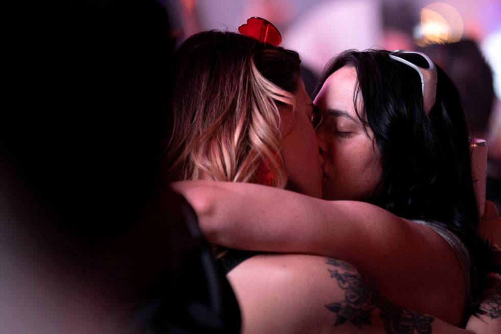 A couple shares a kiss in the middle of the crowd during the second day of electronic dance mus ...