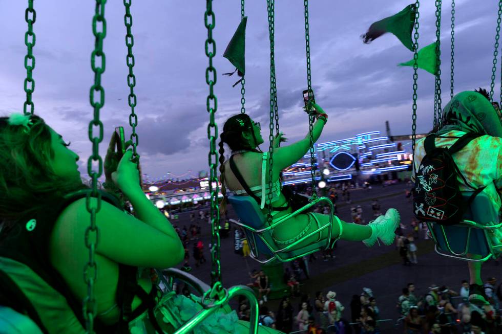 Attendees take selfies on the swings during the second day of electronic dance music festival E ...