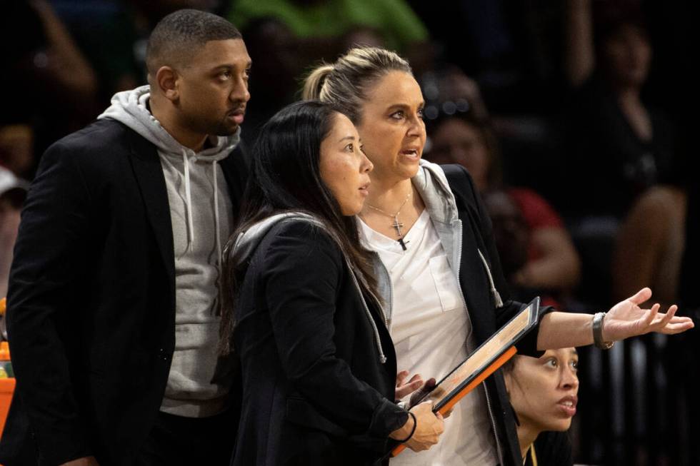 Las Vegas Aces head coach Becky Hammon, right, communicates with assistant coaches Tyler Marsh, ...