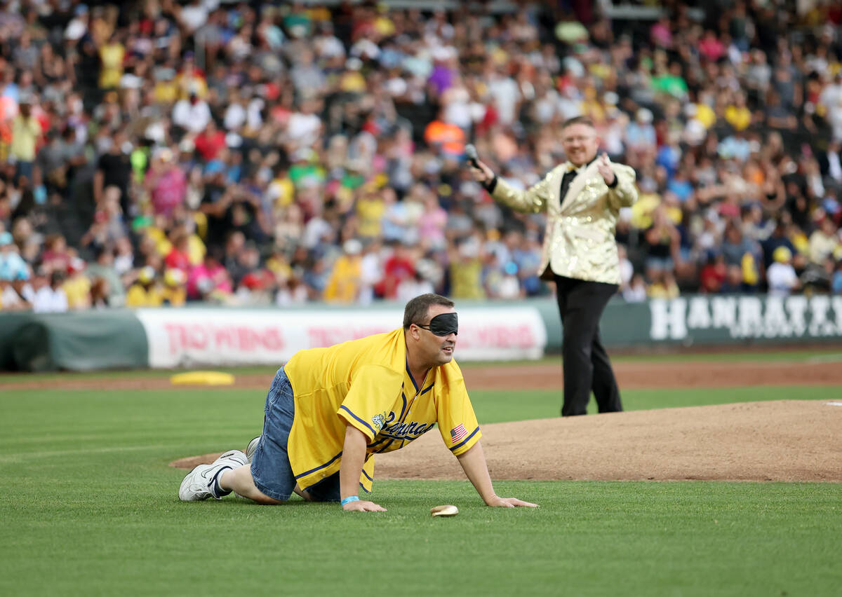 Savannah Bananas fan Joe Pencer searches for a gold banana during a fan game at the Banana Ball ...