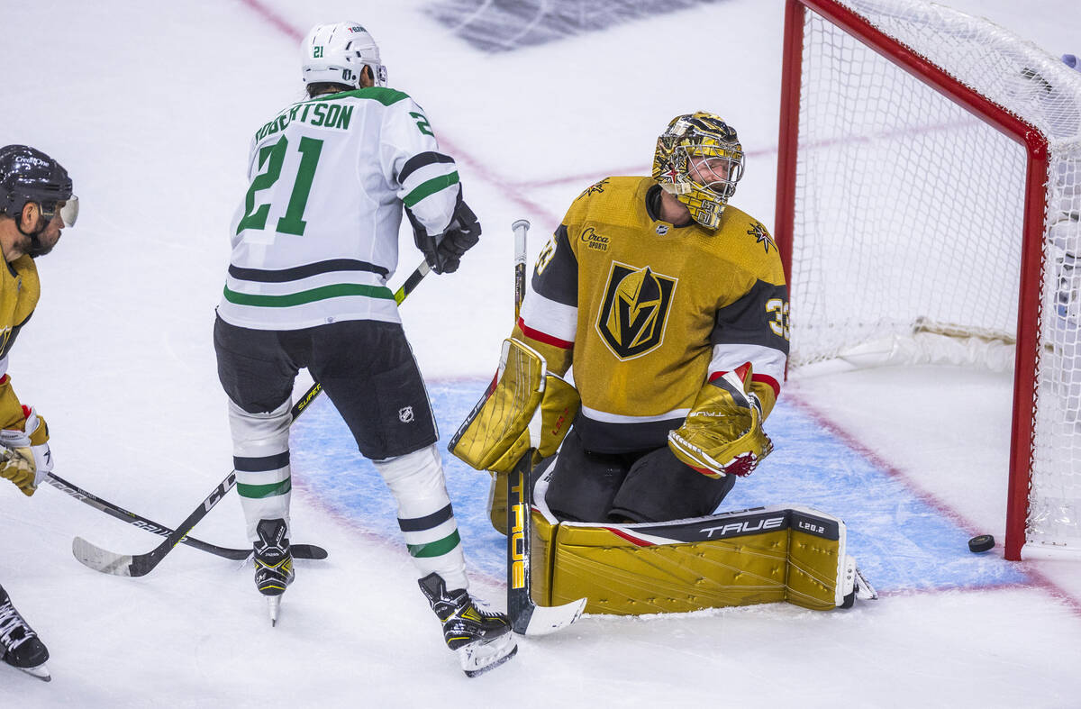 Dallas Stars left wing Jason Robertson (21) scores as Golden Knights goaltender Adin Hill (33) ...