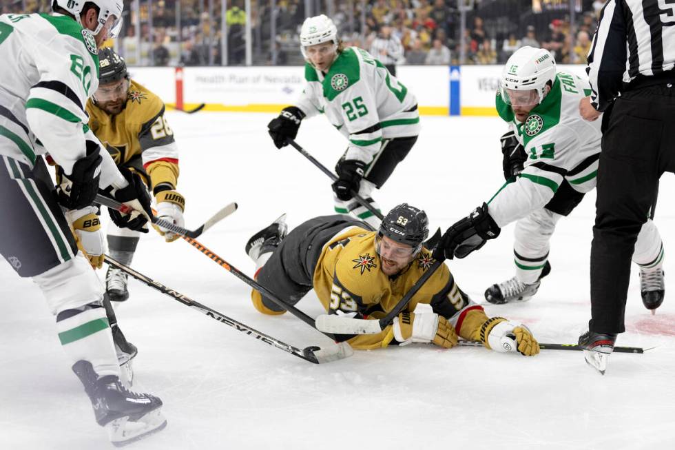 Golden Knights center Teddy Blueger (53) is caught in a puck battle between Knights left wing W ...