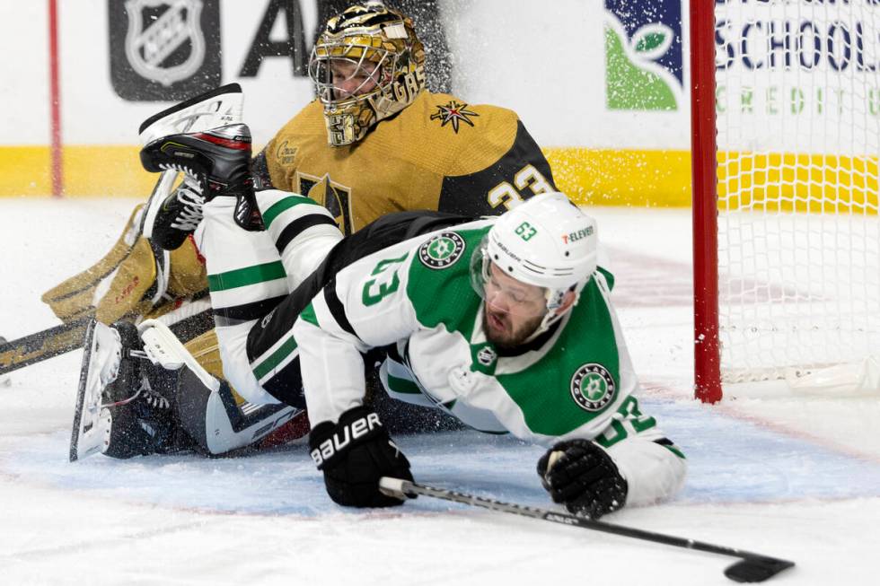 Dallas Stars right wing Evgenii Dadonov (63) falls over Golden Knights goaltender Adin Hill (33 ...