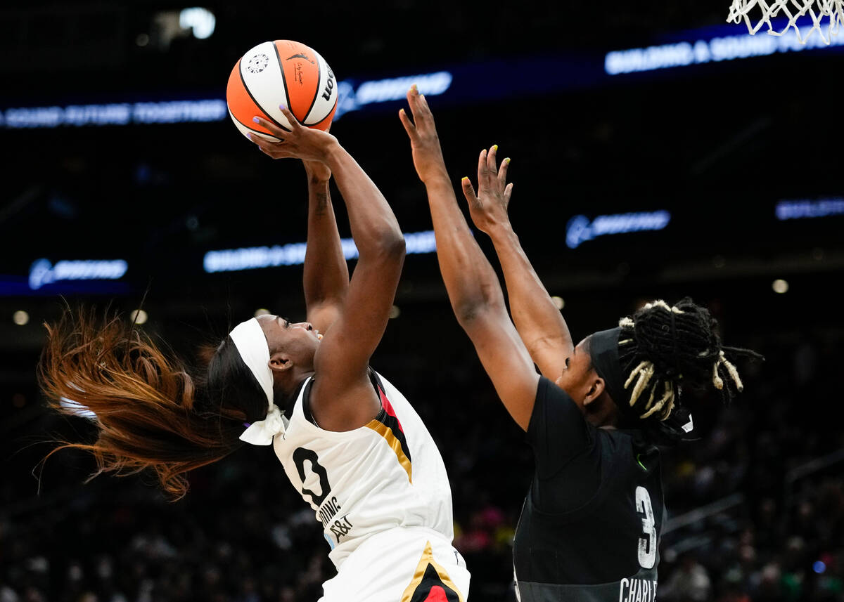 Las Vegas Aces guard Jackie Young (0) drives to the basket against Seattle Storm guard Kaila Ch ...