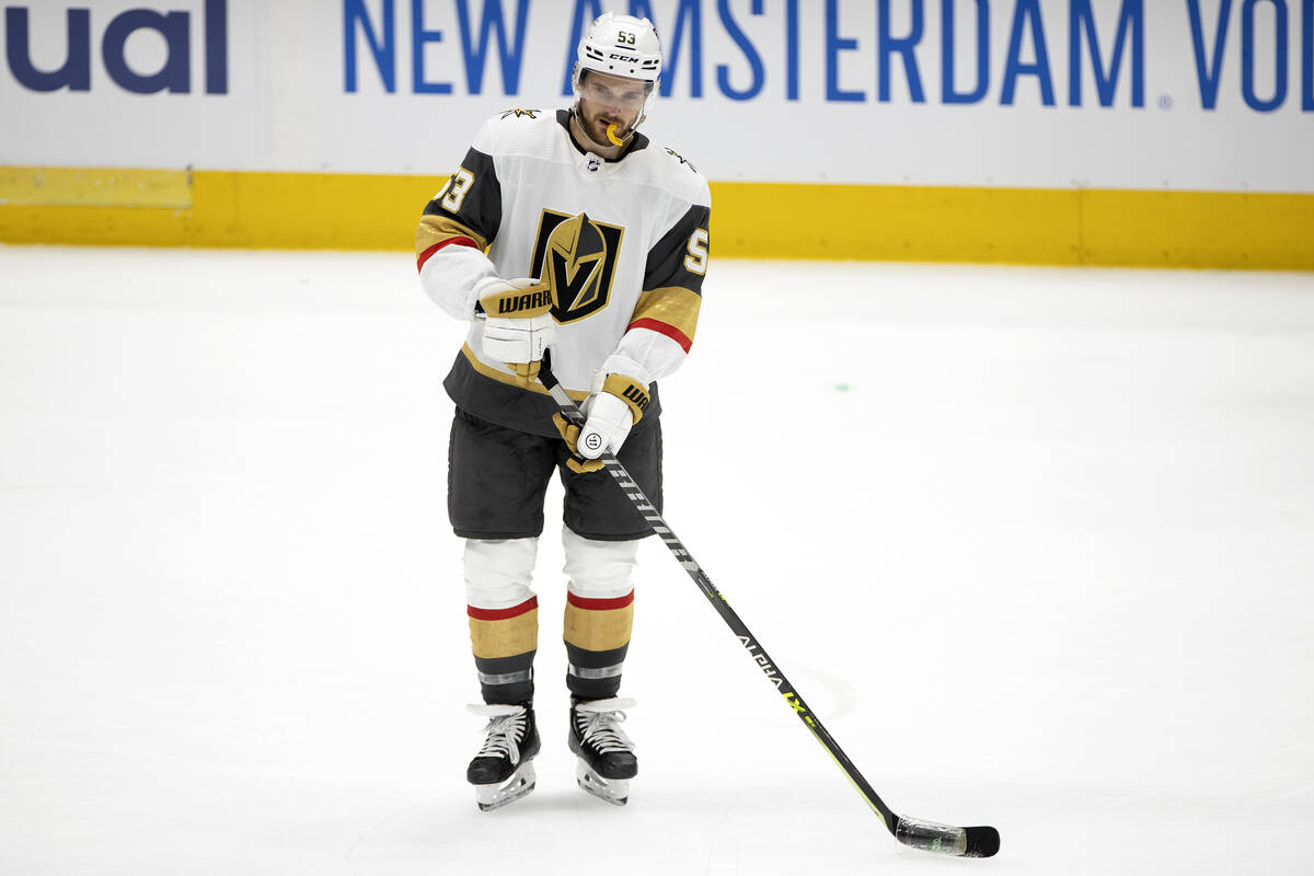 Golden Knights center Teddy Blueger (53) helps to remove debris thrown by Dallas Stars fans off ...