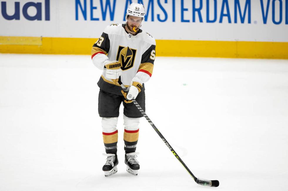 Golden Knights center Teddy Blueger (53) helps to remove debris thrown by Dallas Stars fans off ...