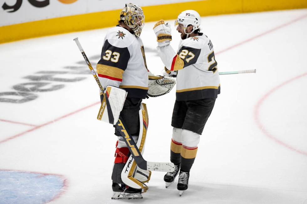 Golden Knights goaltender Adin Hill (33) and defenseman Shea Theodore (27) celebrate after winn ...