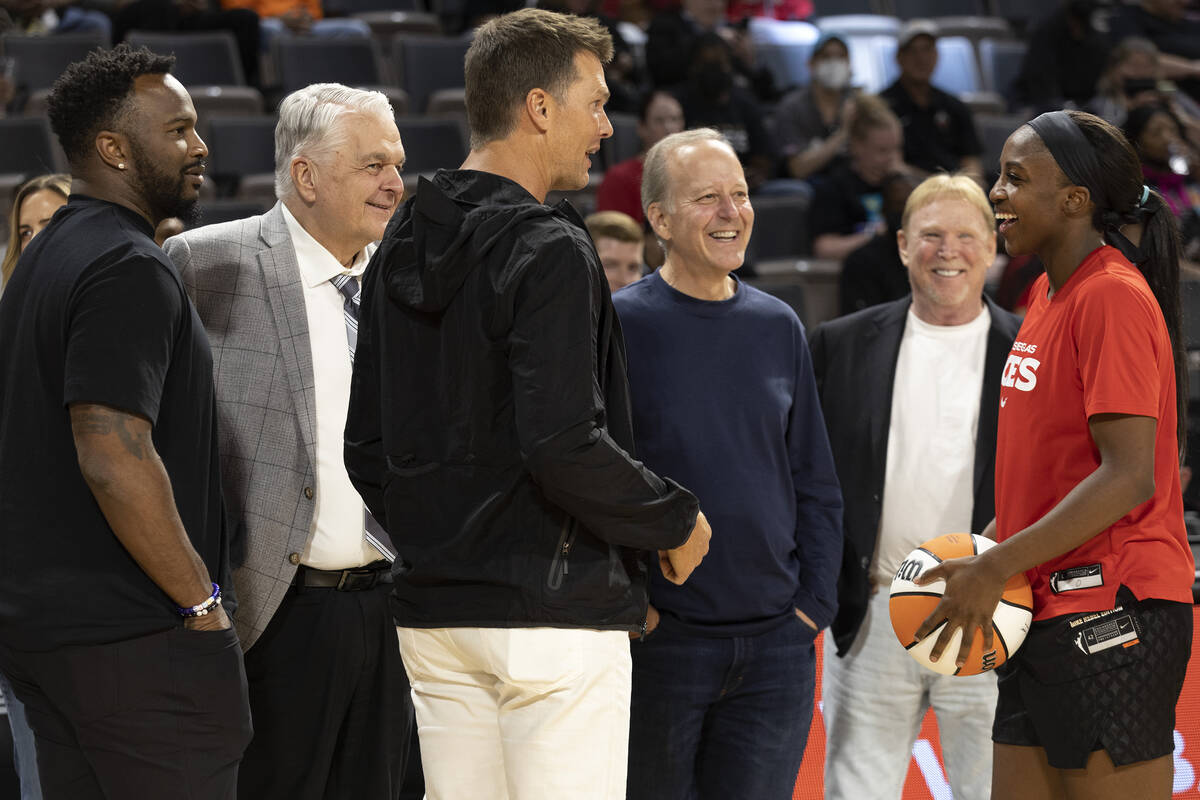 Las Vegas Aces guard Jackie Young (0) laughs with football quarterback Tom Brady, center, durin ...