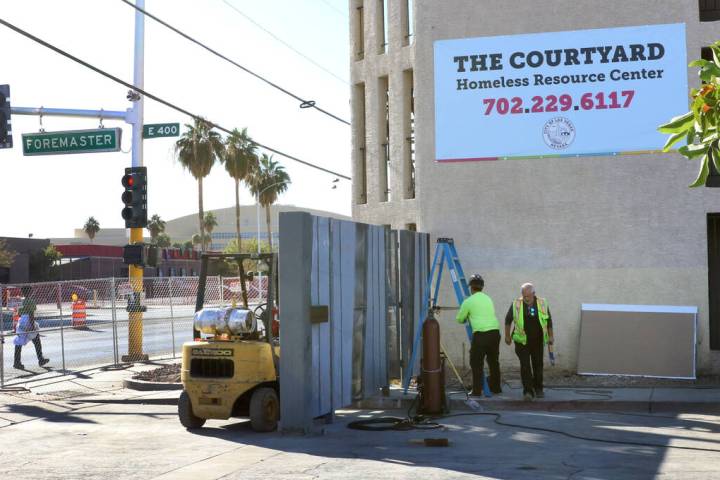 Workers install a gate at the corner of Las Vegas Boulevard and Foremaster Lane near the Courty ...