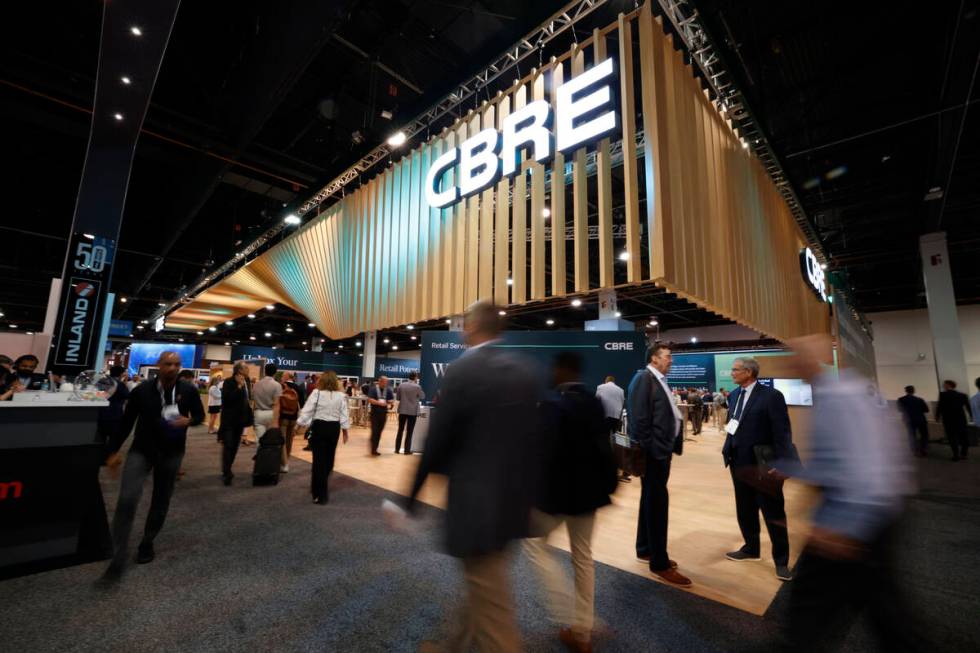 People walk by the CBRE booth at Las Vegas Convention Center, Tuesday, May 23, 2023. (Chitose S ...