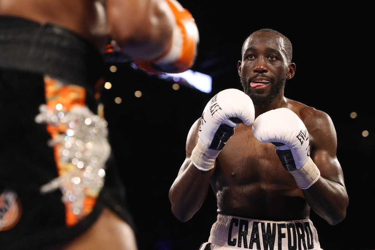 Terence Crawford, right, sticks his tongue out in the seventh round of a WBO welterweight title ...