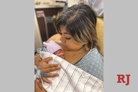 Cristina Celis, who went into labor at the Electric Daisy Carnival, holds her newborn daughter ...
