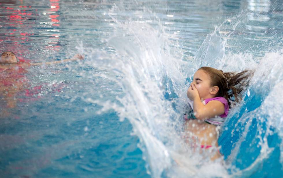 Ashleigh Casillas, 9, right, cannonballs into the water as Julia Urquieta, 8, left, floats at H ...