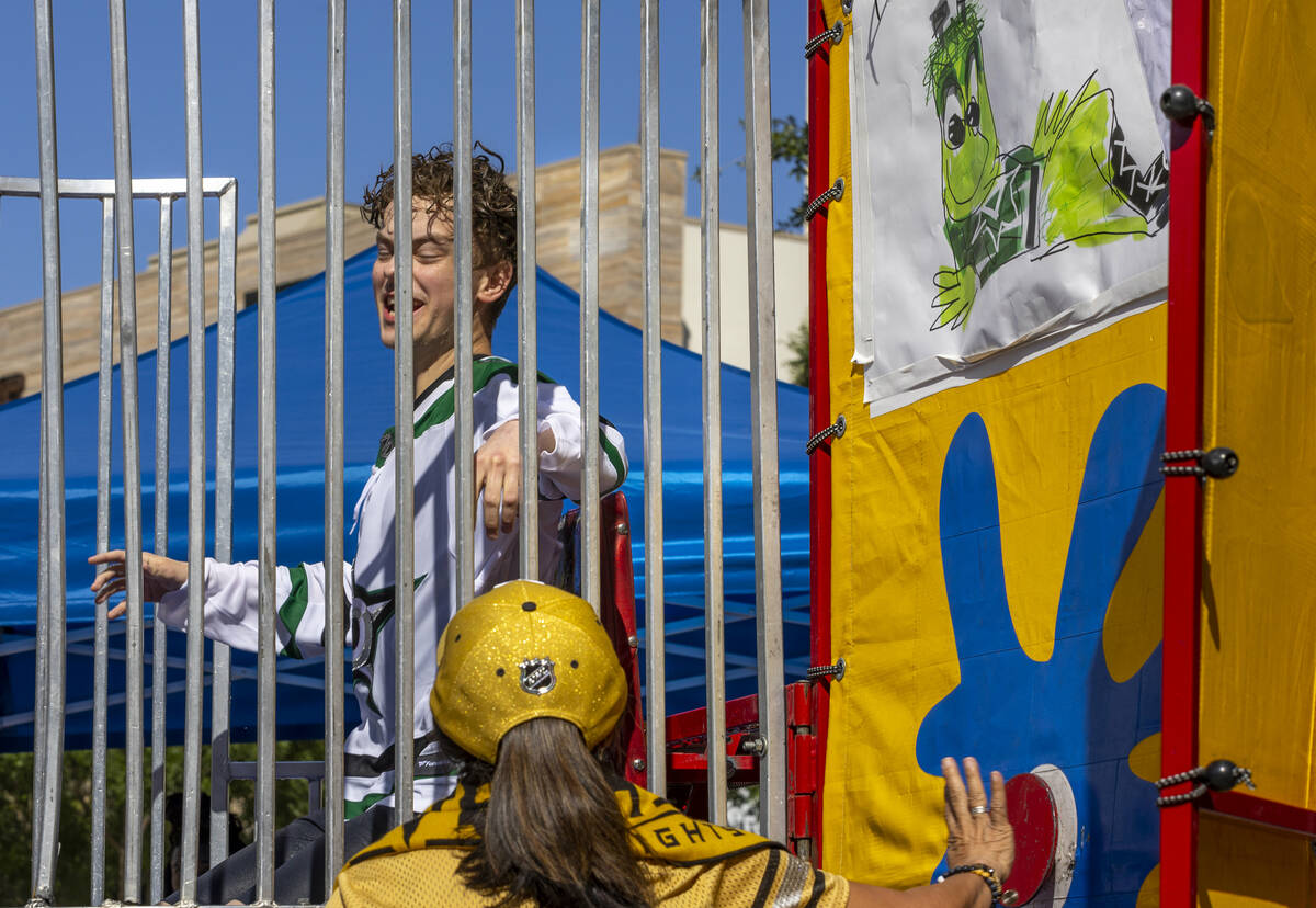 A Golden Knights fan hits the button sending a Dallas Stars fan into the dunk tank water outsid ...